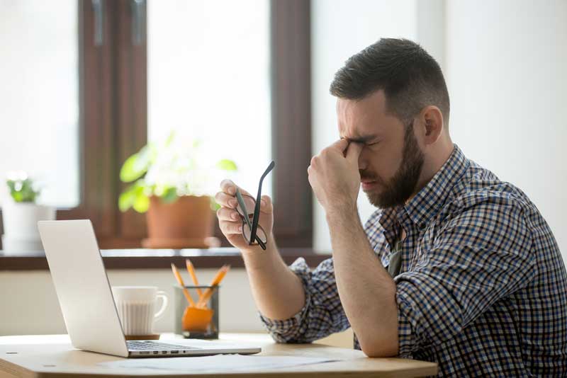 Hombre frente el ordenador cansado y con la vista cansada